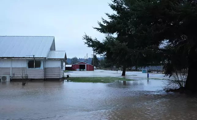 Floodwaters surround homes and buildings after heavy rains, Tuesday, Dec. 9, 2025, in Chehalis, Wash. (AP Photo/Lindsey Wasson)