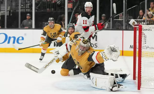 Vegas Golden Knights goaltender Carter Hart (79) stops a shot from the New Jersey Devils during the first period of an NHL hockey game Wednesday, Dec. 17, 2025, in Las Vegas. (AP Photo/Candice Ward)