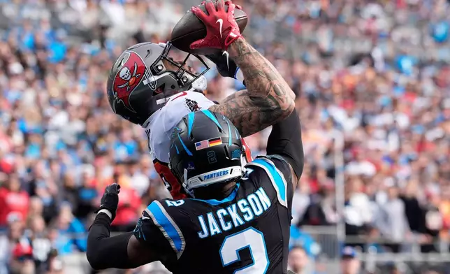 Tampa Bay Buccaneers wide receiver Mike Evans catches a touchdown pass against Carolina Panthers cornerback Mike Jackson during the first half of an NFL football game, Sunday, Dec. 21, 2025, in Charlotte, N.C. (AP Photo/Jacob Kupferman)