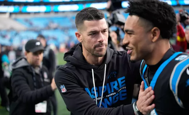 Carolina Panthers head coach Dave Canales greets quarterback Bryce Young after their win against the Tampa Bay Buccaneers in an NFL football game, Sunday, Dec. 21, 2025, in Charlotte, N.C. (AP Photo/Jacob Kupferman)