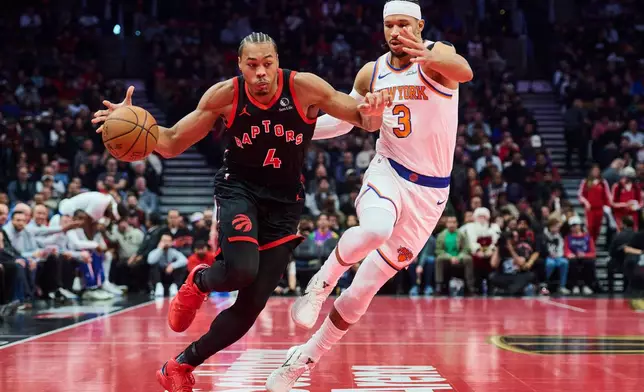 Toronto Raptors' Scottie Barnes (4) drives past New York Knicks' Josh Hart (3) during the first half of an NBA Cup basketball game in Toronto, Tuesday, Dec. 9, 2025. (Sammy Kogan/The Canadian Press via AP)