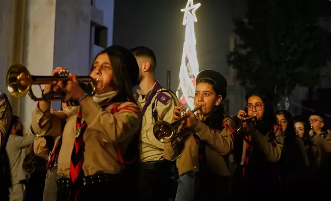 A Scout band plays during the lighting ceremony of a Christmas tree at the Greek Orthodox Mar Elias Church, months after the church was the site of a deadly suicide bombing, in the Dweila neighborhood of Damascus, Syria, Tuesday, Dec. 23, 2025. (AP Photo/Omar Sanadiki)