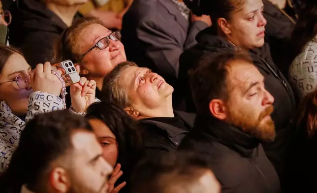 People attend the lighting of a Christmas tree at the Greek Orthodox Mar Elias Church, months after the church was the site of a deadly suicide bombing, in the Dweila neighborhood of Damascus, Syria, Tuesday, Dec. 23, 2025.(AP Photo/Omar Sanadiki)