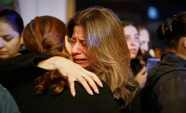 Two women hug each other as they attend the lighting of a Christmas tree at the Greek Orthodox Mar Elias Church, months after the church was the site of a deadly suicide bombing, in the Dweila neighborhood of Damascus, Syria, Tuesday, Dec. 23, 2025.(AP Photo/Omar Sanadiki)