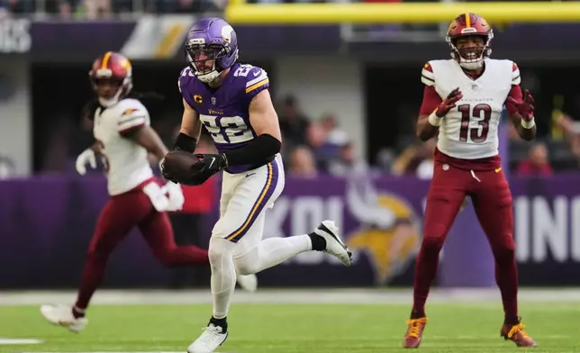 Minnesota Vikings safety Harrison Smith (22) runs with the ball after intercepting a pass during the second half of an NFL football game against the Washington Commanders, Sunday, Dec. 7, 2025, in Minneapolis. (AP Photo/Abbie Parr)