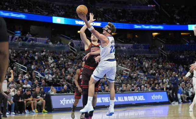 Orlando Magic forward Franz Wagner, makes a shot over Chicago Bulls center Nikola Vucevic during the first half of an NBA basketball game, Monday, Dec. 1, 2025, in Orlando, Fla. (AP Photo/John Raoux)
