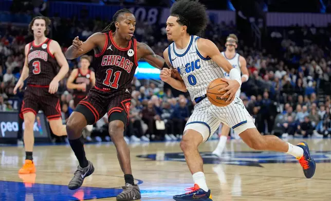 Orlando Magic guard Anthony Black (0) drives past Chicago Bulls guard Ayo Dosunmu (11) during the first half of an NBA basketball game, Monday, Dec. 1, 2025, in Orlando, Fla. (AP Photo/John Raoux)