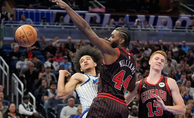Orlando Magic guard Anthony Black, left, loses control of the ball as he collides with Chicago Bulls forward Patrick Williams (44) and guard Kevin Huerter (13) during the first half of an NBA basketball game, Monday, Dec. 1, 2025, in Orlando, Fla. (AP Photo/John Raoux)