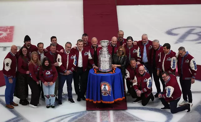 Members from the 1996 Stanley Cup Championship team of the Colorado Avalanche gather for a group shot during a ceremony to mark the 30th anniversary of winning the Cup before an NHL hockey game against the Florida Panthers, Thursday, Dec. 11, 2025, in Denver. (AP Photo/David Zalubowski)