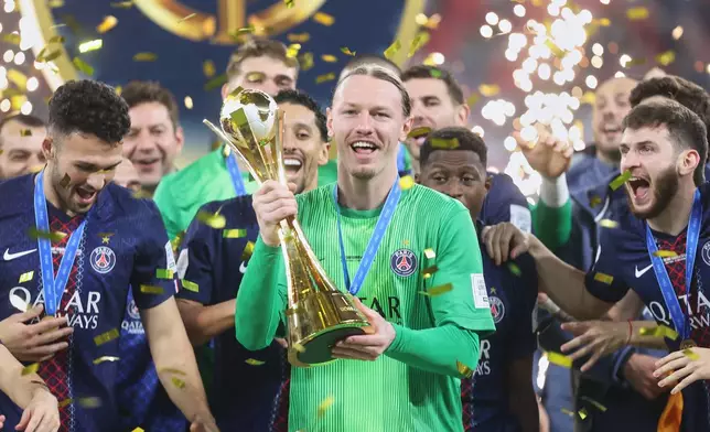 PSG's goalkeeper Matvey Safonov holds the trophy after winning the FIFA Intercontinental Cup final soccer match between Flamengo and Paris Saint-Germain in Doha, Qatar, Wednesday, Dec. 17, 2025. (AP Photo/Hussein Sayed)