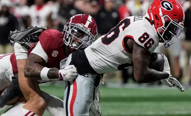 Georgia running back Nate Frazier (3) is hit by Alabama defensive back Keon Sabb (3) during the first half of a Southeastern Conference championship NCAA college football game, Saturday, Dec. 6, 2025, in Atlanta. (AP Photo/Mike Stewart)