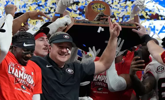 Georgia head coach Kirby Smart and team celebrate after a Southeastern Conference championship NCAA college football game against Alabama, Saturday, Dec. 6, 2025, in Atlanta. (AP Photo/Mike Stewart)