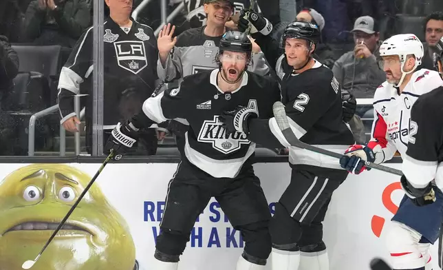 Los Angeles Kings right wing Adrian Kempe, left, celebrates his goal with defenseman Brian Dumoulin, center, as Washington Capitals left wing Alex Ovechkin skates by during the second period of an NHL hockey game Tuesday, Dec. 2, 2025, in Los Angeles. (AP Photo/Mark J. Terrill)