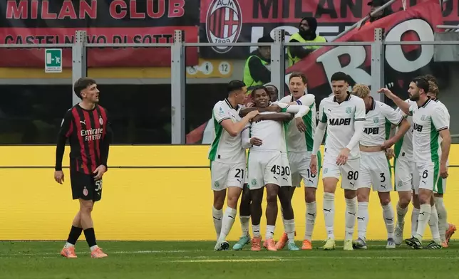 Sassuolo's Armand Lauriente celebrates with teammates after scoring his side's second goal during the Serie A soccer match between AC Milan and Sassuolo, in Milan, Italy, Sunday, Dec. 14, 2025. (AP Photo/Luca Bruno)