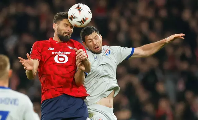 Lille's Olivier Giroud, left, challenges for the ball with Dinamo's Scott McKenna during the Europa League opening phase soccer match between Lille and GNK Dinamo Zagreb in Villeneuve-d'Ascq, outside Lille, France, Thursday, Nov. 27, 2025. (AP Photo/Jean-Francois Badias)