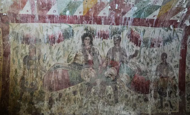 A Roman-era fresco depicting a banquet scene is seen inside a newly uncovered tomb in Hisardere, in Iznik in northwestern Turkey, Friday, Dec. 12, 2025. (AP Photo/Khalil Hamra)