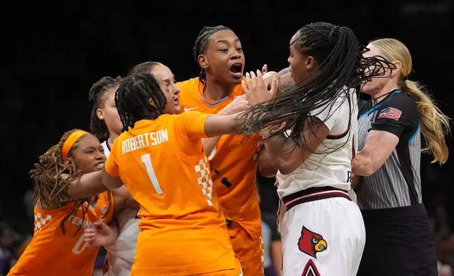 Louisville's Mackenly Randolph, right, fights for control of the ball with Zee Spearman as Nya Robertson (1) and an official attempt to separate them during the second half of an NCAA college basketball game Saturday, Dec. 20, 2025, in New York. (AP Photo/Frank Franklin II)