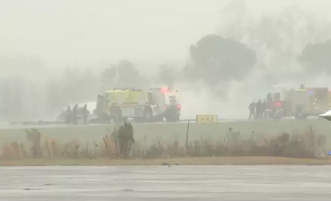 This screengrab made from video provided by WSOC shows firefighting crews responding to a reported plane crash at a regional airport in Statesville, N.C., erupting in a large fire, Thursday, Dec. 18, 2025. (WSOC via AP)