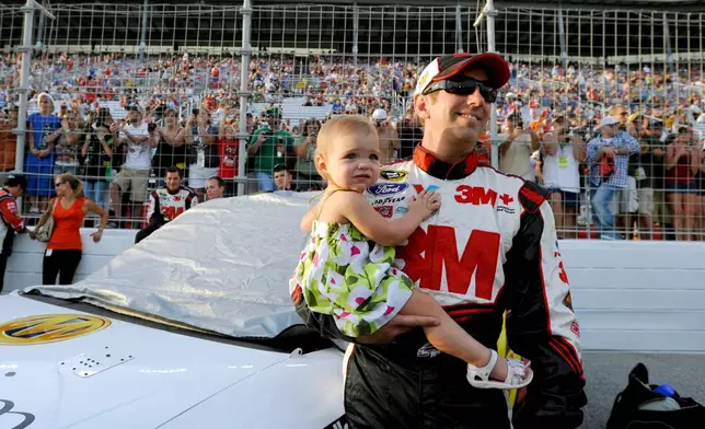 Greg Biffle holds his daughter, Emma, before the NASCAR Sprint Cup Series auto race at Atlanta Motor Speedway, Sunday, Sept. 2, 2012, in Hampton, Ga. (AP Photo/Rainier Ehrhardt)