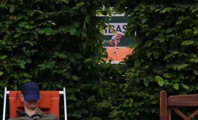 A spectator takes a nap next to a court of the French Tennis Open, at the Roland-Garros stadium, in Paris, May 29, 2025. (AP Photo/Lindsey Wasson, File)