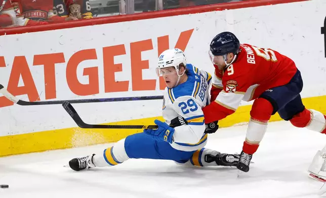 St. Louis Blues right wing Jonatan Berggren (29) and Florida Panthers center Sam Bennett (9) chase the puck during the second period of an NHL hockey game, Saturday, Dec. 20, 2025, in Sunrise, Fla. (AP Photo/Rhona Wise)