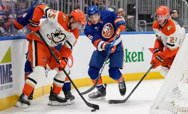 Anaheim Ducks center Ryan Poehling (25) fights for control of the puck with New York Islanders center Marc Gatcomb (16) during the second period of an NHL hockey game, Thursday, Dec. 11, 2025, in Elmont, N.Y. (AP Photo/Yuki Iwamura)