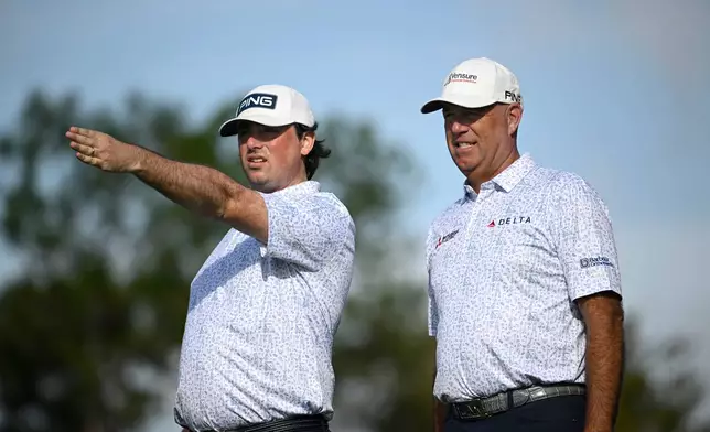 Stewart Cink, right, and his son Reagan Cink, discuss a tee shot on the second hole during the final round of the PNC Championship golf tournament, Sunday, Dec. 21, 2025, in Orlando, Fla. (AP Photo/Phelan M. Ebenhack)