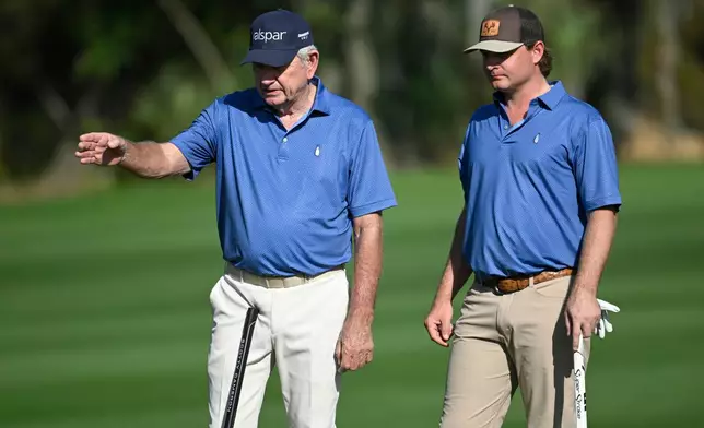 Nick Price, left, of Zimbabwe, discusses their putt with his son Greg Price on the first green during the final round of the PNC Championship golf tournament, Sunday, Dec. 21, 2025, in Orlando, Fla. (AP Photo/Phelan M. Ebenhack)