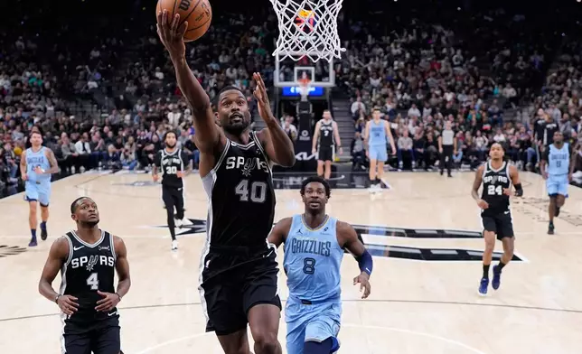 San Antonio Spurs forward Harrison Barnes (40) scores past Memphis Grizzlies forward Jaren Jackson Jr. (8) during the second half of an NBA basketball game in San Antonio, Tuesday, Dec. 2, 2025. (AP Photo/Eric Gay)
