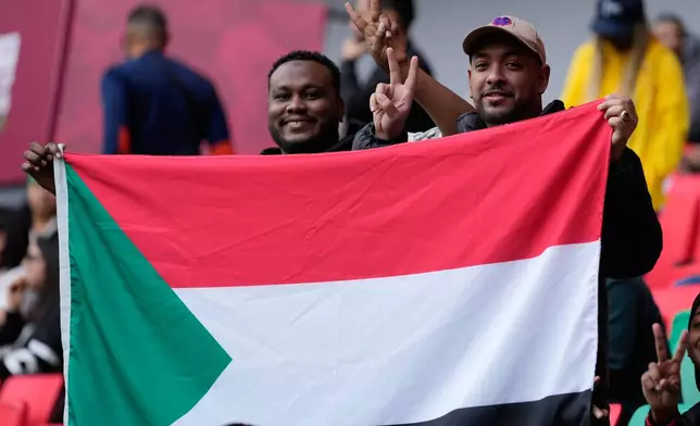 Sudan fans hold their national flag ahead of the Africa Cup of Nations group E soccer match between Algeria and Sudan in Rabat, Morocco, Wednesday, Dec. 24, 2025. (AP Photo/Mosa'ab Elshamy)