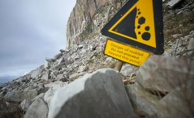 A danger sign near the steep cliff and granite quarry on Ailsa Craig island off the coast of Scotland, Monday, Nov. 10, 2025. (AP Photo/Alastair Grant)