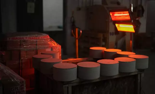 Ailsa Craig common green granite curling stone blanks are dried under a heater as they wait further machining at the Kays Curling stone factory on Mauchline, Scotland, Tuesday, Nov. 11, 2025. (AP Photo/Alastair Grant)
