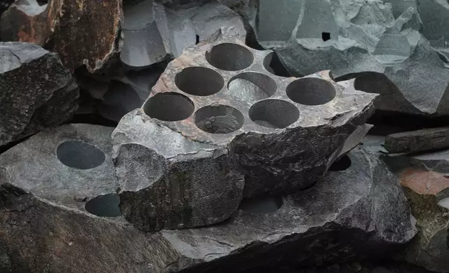 Granite rock that has been used to create curling stone blocks lies outside Kays Curling stone factory in Mauchline, Scotland, Tuesday, Nov. 11, 2025. (AP Photo/Alastair Grant)