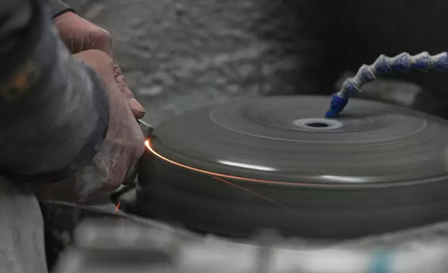 A groove is made on a curling stone by a craftsman at Kays Curling stone factory in Mauchline, Scotland, Tuesday, Nov. 11, 2025. (AP Photo/Alastair Grant)