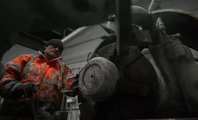 A craftsman works on machining Ailsa Craig Common Green granite into the shape of a churning stone at Kays Curling stone factory in Mauchline, Scotland, Tuesday, Nov. 11, 2025. (AP Photo/Alastair Grant)