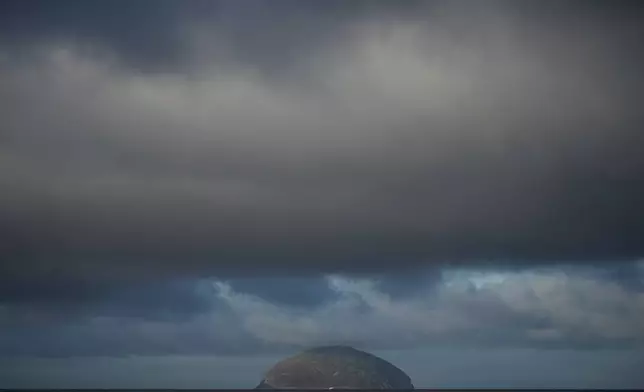 The island of Ailsa Craig, where the two types of granite, Common Green and Blue Hone, that are used to make curling stones is quarried from, is seen from the beach at Girvan, Scotland, Thursday, Nov. 13, 2025. (AP Photo/Alastair Grant)