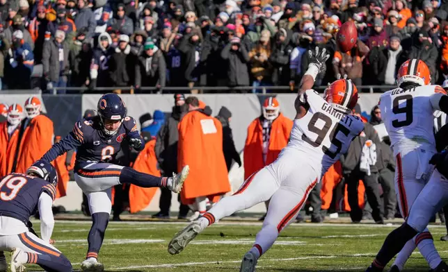 Chicago Bears place kicker Cairo Santos (8) kicks his field goal attempt past Cleveland Browns defensive end Myles Garrett, but misses the field goal in the first half of an NFL football game in Chicago, Sunday, Dec. 14, 2025. (AP Photo/Nam Y. Huh)