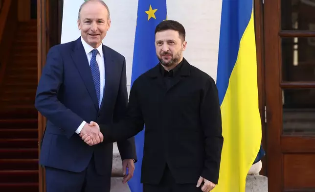 CAPTION CORRECTS SPELLING OF NAME Ukraine's President Volodymyr Zelenskyy, right, shakes hands with the Irish Prime Minister Micheal Martin upon his arrival at Government Buildings in Dublin, Ireland, Tuesday, Dec. 2, 2025. (AP Photo/Peter Morrison)