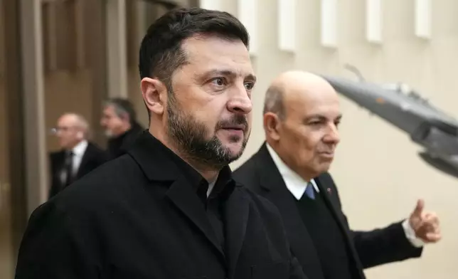 Ukrainian President Volodymyr Zelenskyy, front, arrives to visit the Dassault Aviation plant, in Cergy, northwest of Paris, France, Monday, Dec. 1, 2025. (Dimitar Dilkoff/Pool Photo via AP)