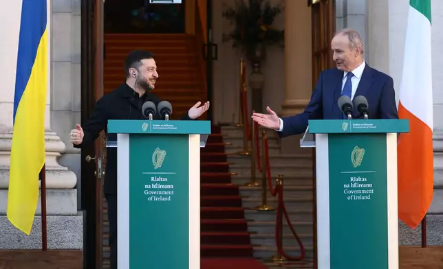 Ukraine's President Volodymyr Zelenskyy, left, and the Irish Prime Minister Micheal Martin gesture to each other as they take part in a joint press conference in Dublin, Ireland, Tuesday, Dec. 2, 2025. (AP Photo/Peter Morrison)