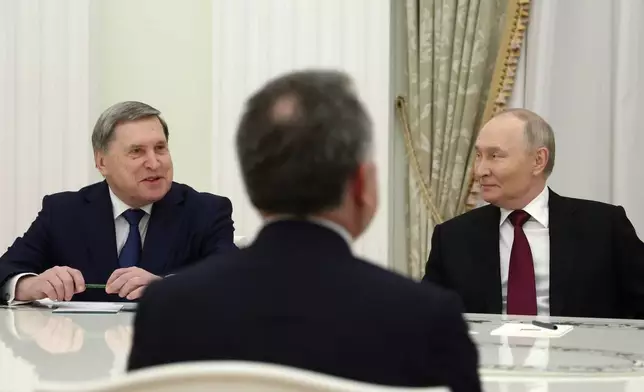 Russian President Vladimir Putin, right, and Russian Presidential foreign policy adviser Yuri Ushakov, left, attend the talks with U.S. special envoy Steve Witkoff, back to a camera, at the Senate Palace of the Kremlin in Moscow, Russia, Tuesday, Dec. 2, 2025. (Alexander Kazakov, Sputnik, Kremlin Pool Photo via AP)