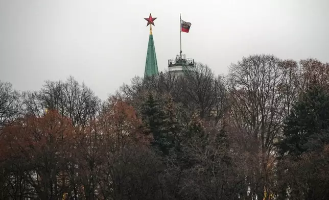 A red star atop of the Spasskaya Tower, left, and a Presidential Standard atop of the Senate Palace in the Moscow Kremlin, in Moscow, Tuesday, Dec. 2, 2025. (AP Photo/Alexander Zemlianichenko)