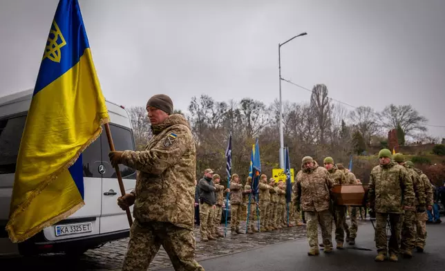 Servicemen carry the coffin of volunteer soldier Yukhym Agafontsev, 22, killed in a battle with the Russian troops, during a farewell ceremony in Kyiv, Ukraine, Tuesday, Dec. 2, 2025. (AP Photo/Dan Bashakov)