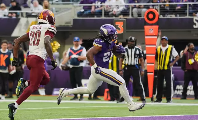 Minnesota Vikings running back Jordan Mason (27) scores a touchdown during the first half of an NFL football game against the Washington Commanders, Sunday, Dec. 7, 2025, in Minneapolis. (AP Photo/Abbie Parr)