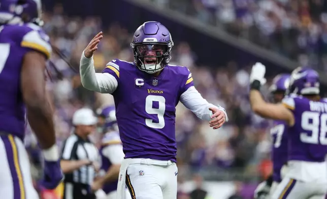 Minnesota Vikings quarterback J.J. McCarthy (9) reacts after running back Jordan Mason, foreground left, scored a touchdown during the first half of an NFL football game against the Washington Commanders, Sunday, Dec. 7, 2025, in Minneapolis. (AP Photo/Matt Krohn)
