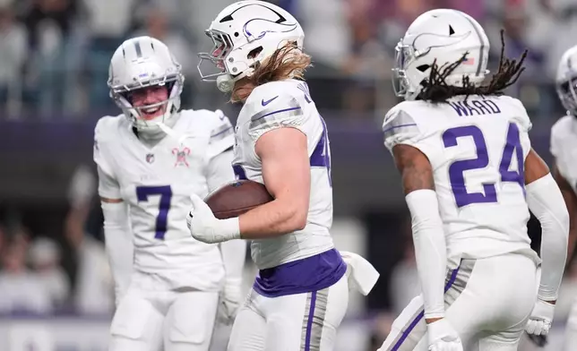 Minnesota Vikings linebacker Andrew van Ginkel, center, celebrates with cornerback Byron Murphy Jr., left, and safety Jay Ward after recovering a fumble by Detroit Lions quarterback Jared Goff, not pictured, during the first half of an NFL football game, Thursday, Dec. 25, 2025, in Minneapolis. (AP Photo/Abbie Parr)