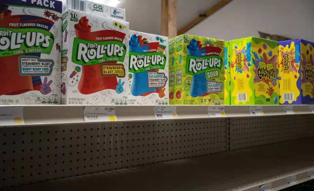 Fruit Roll-Ups and Gushers sit on a shelf of a grocery store above an empty shelf in Ambler, Alaska, Wednesday, Oct. 1, 2025. (AP Photo/Annika Hammerschlag)