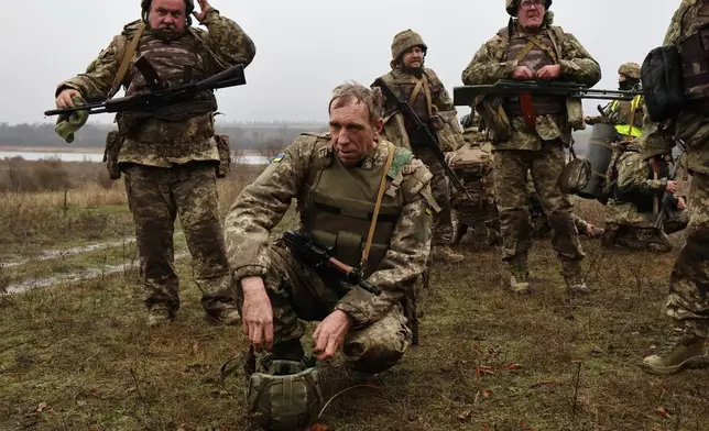 In this photo provided by Ukraine's 65th Mechanized Brigade press service, recruits rest after drills at a training ground in the Zaporizhzhia region, Ukraine, Friday, Dec. 12, 2025. (Andriy Andriyenko/Ukraine's 65th Mechanized Brigade via AP)