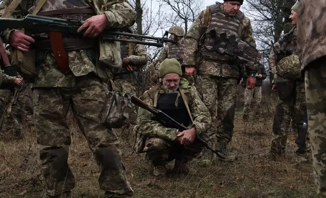 In this photo provided by Ukraine's 65th Mechanized Brigade press service, recruits rest after drills at a training ground in the Zaporizhzhia region, Ukraine, Friday, Dec. 12, 2025. (Andriy Andriyenko/Ukraine's 65th Mechanized Brigade via AP)