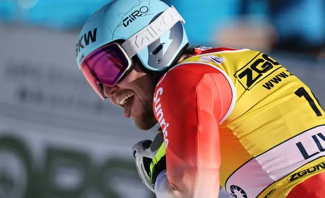 Switzerland's Alexis Monney celebrates at the finish area of an alpine ski, men's World Cup Super G, in Livigno, Italy, Saturday, Dec. 27, 2025. (AP Photo/Marco Trovati)